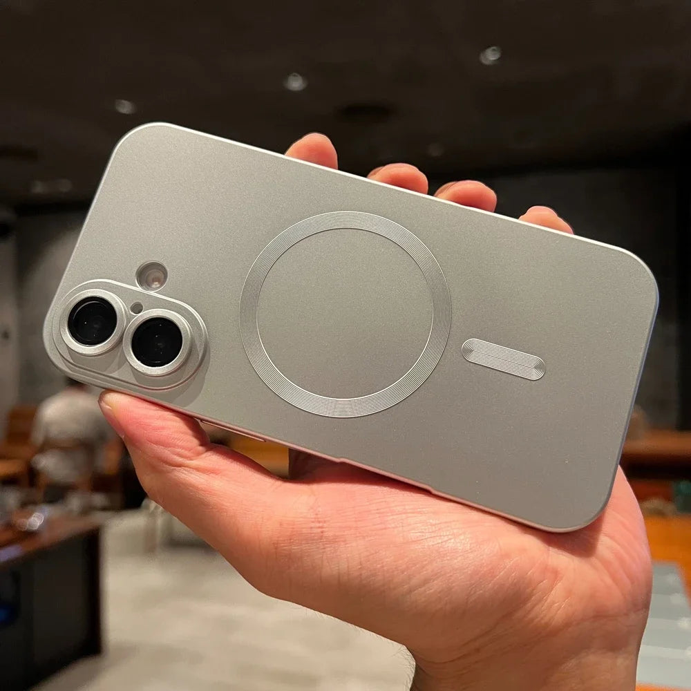 Hand holding a silver smartphone with a blurred indoor background