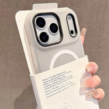 Phone case with camera lens design held by a hand against a neutral background