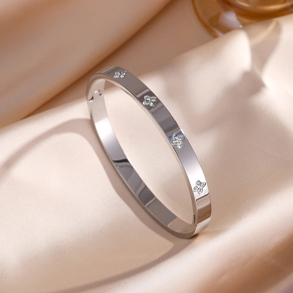 Silver bracelet with engraved designs on a soft beige background