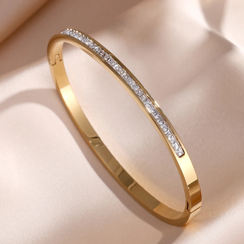 Gold bracelet with diamonds on a beige background