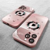 Two pink phone cases with a unique design on a gray fabric background