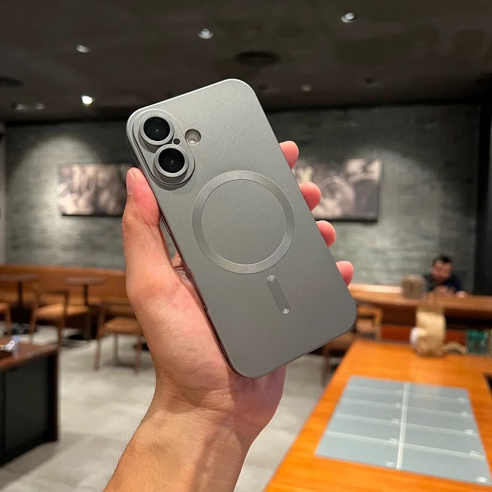 Person holding a silver phone case with a blurred restaurant interior in the background